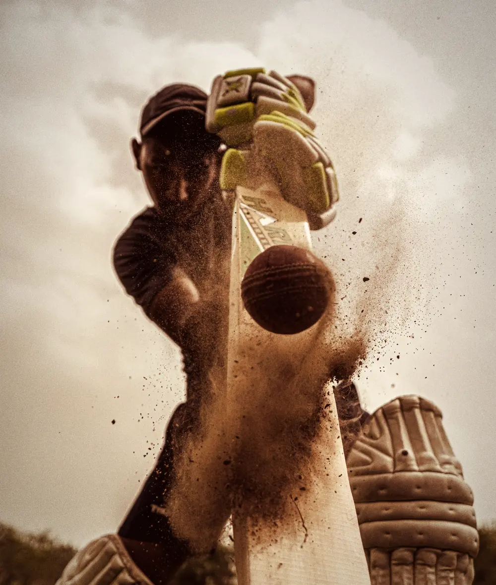 A batter hits the ball through a burst of dust
