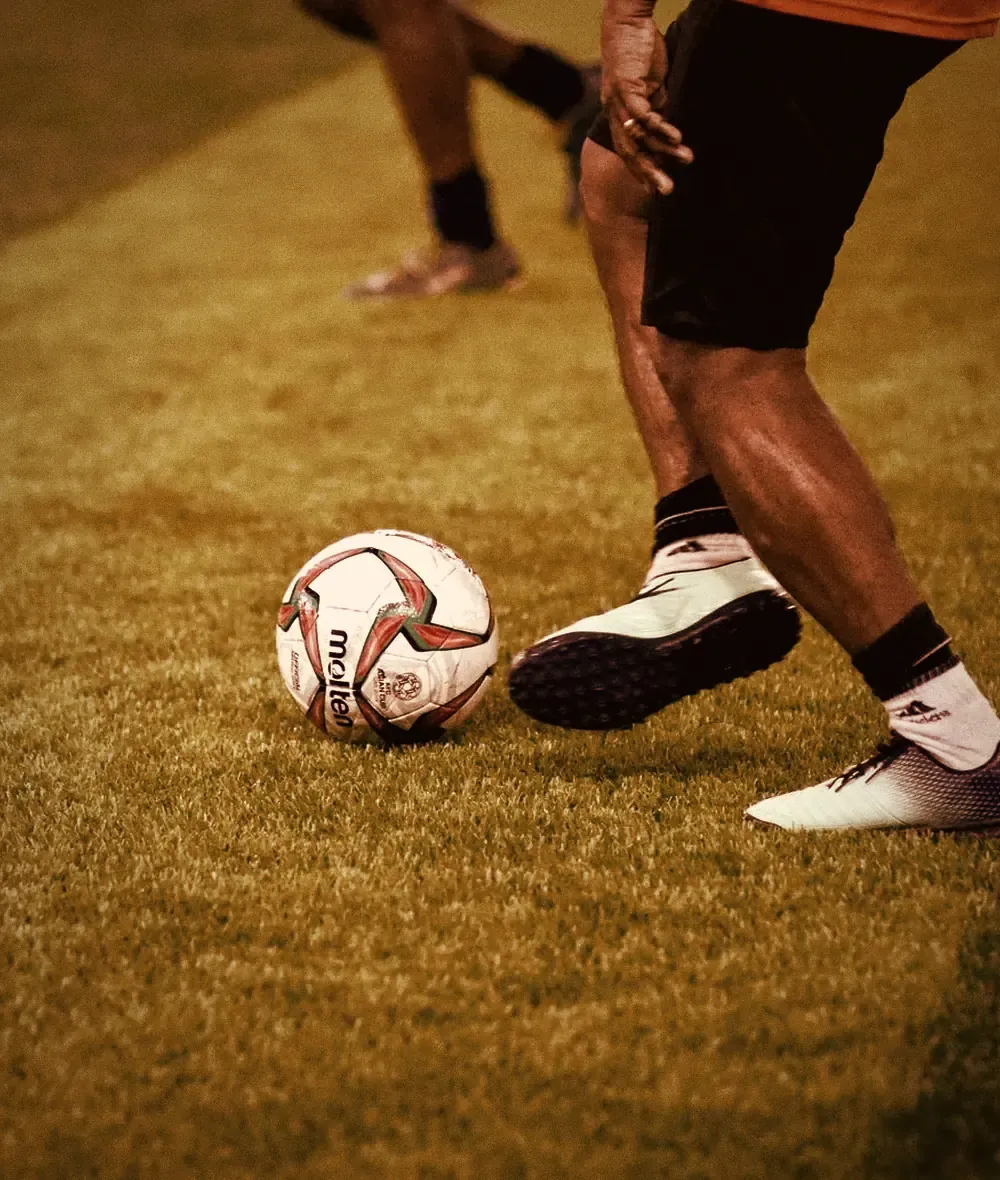 A footballer controls the ball on the pitch: ION Strips for match days