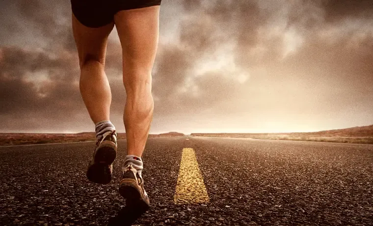 A runner on an open road at sunset